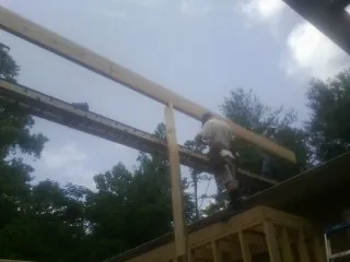 Carpenter setting a ridge beam over a new addition frame — Ice Dam Removal by Roofing Brothers in Bandon