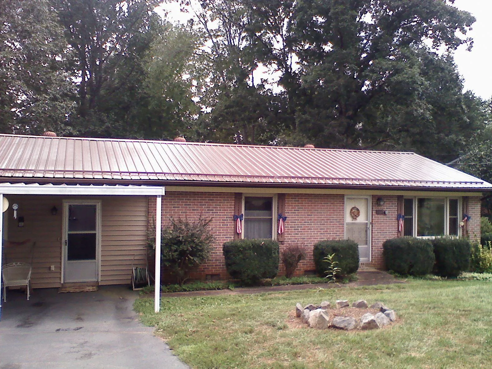 Bronze metal roof and carport on a brick ranch home — Roof Repair work by our crew in Bandon